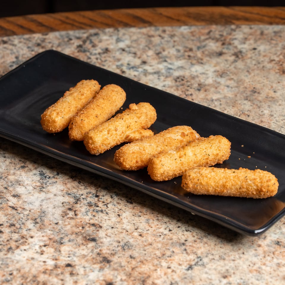 Six crispy golden mozzarella sticks on a black rectangular plate.