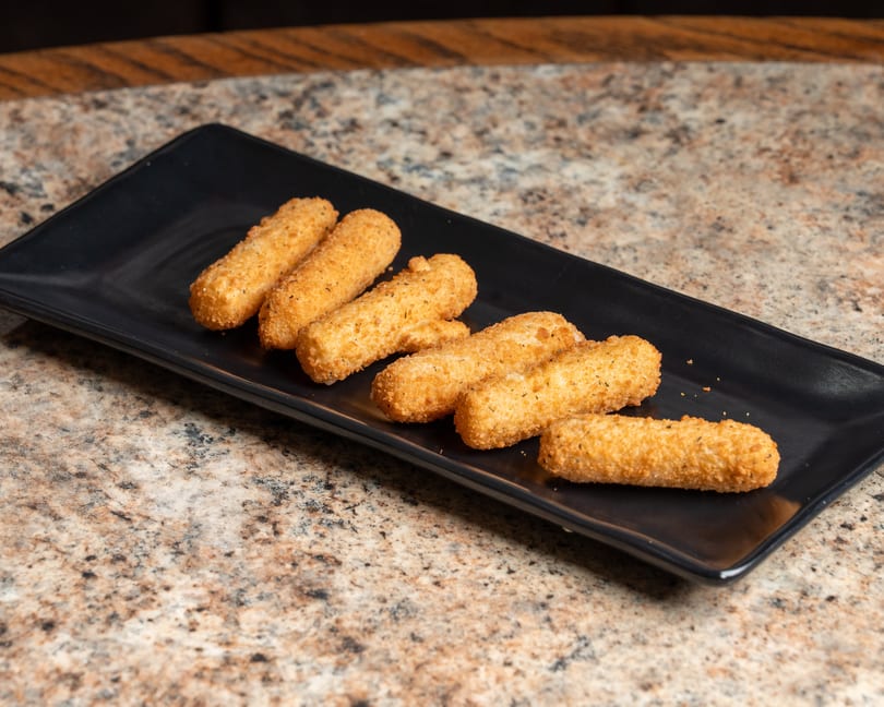 Six crispy golden mozzarella sticks on a black rectangular plate.