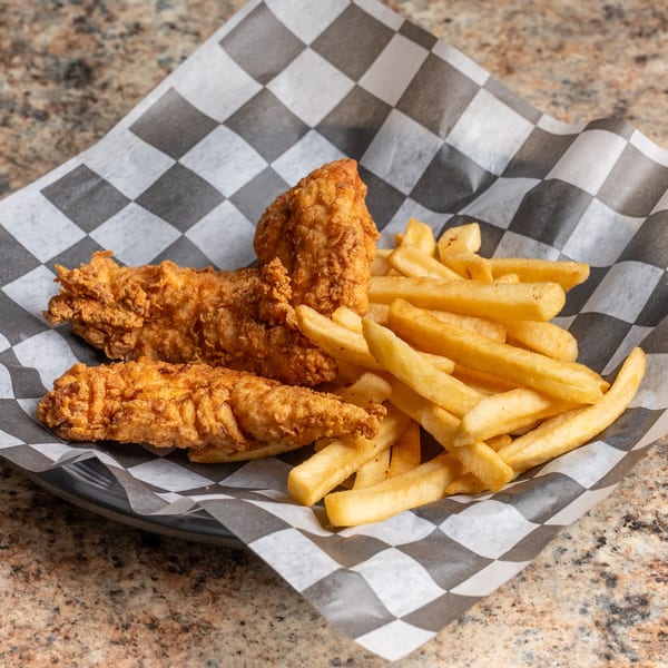 Three crispy chicken tenders and a pile of golden french fries in a checkered paper-lined basket.